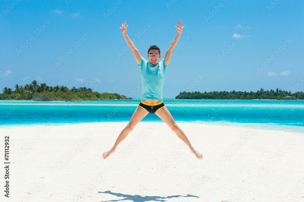 Man jump on beach with two islands on the background, happiness Man jump on beach with two islands on the background, happiness