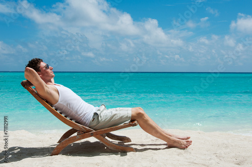 Man sunbathing on the beach near the ocean