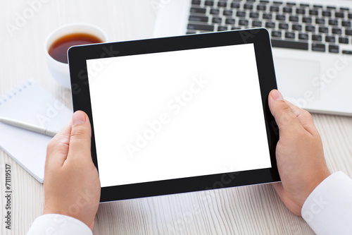 tablet with isolated screen in male hands over the table