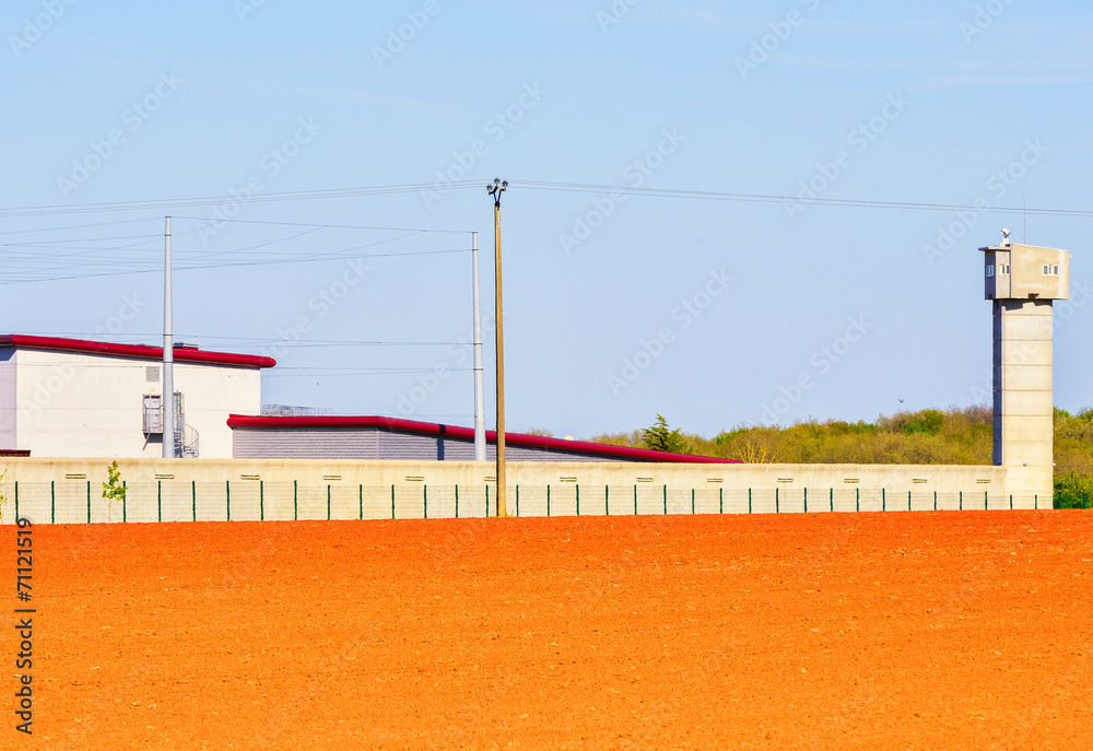 Large prison area with a tall watchtower surrounded
