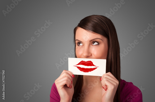 Happy pretty woman holding card with kiss lipstick mark