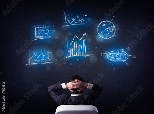 Businessman in chair looking at charts