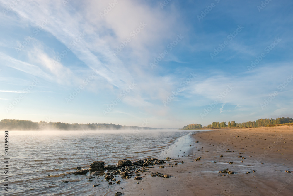 Sandy beach misty river early in the morning