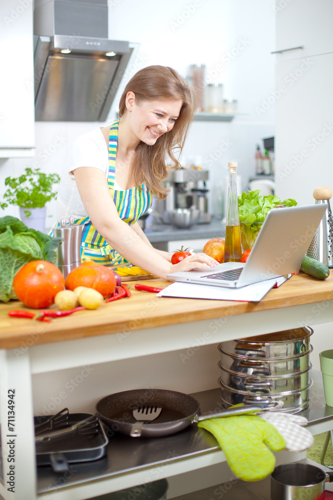 Frau mit laptop in der küche 