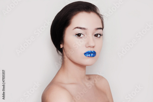 Девушка с блестящими синими губами на светлом фоне