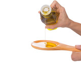 Pouring olive oil on wooden spoon