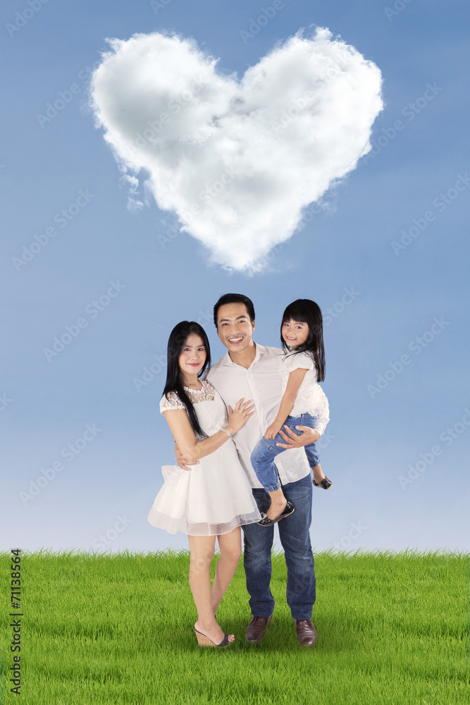 Cheerful family under cloud shaped heart Cheerful family under cloud shaped heart
