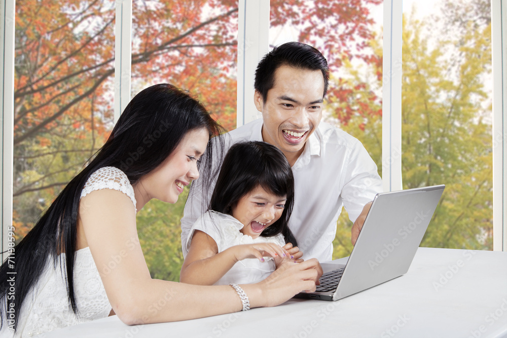 Cheerful family with laptop at home Cheerful family with laptop at home