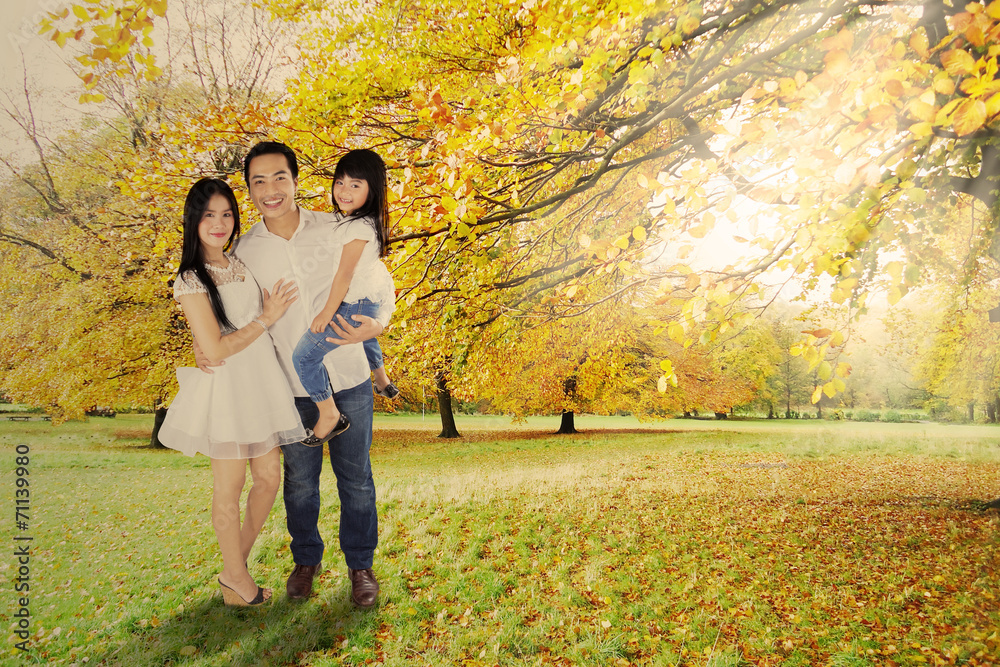 Fototapeta premium Full length of family under autumn tree