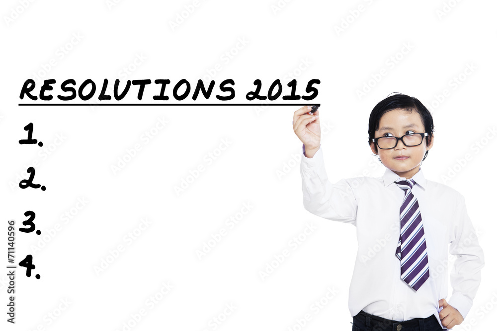 Little boy writes his resolutions in 2015