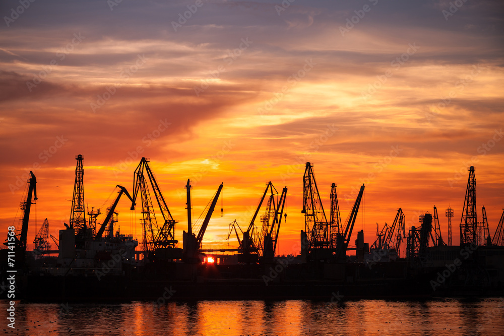 Black silhouettes of cranes and cargo ships in Varna port