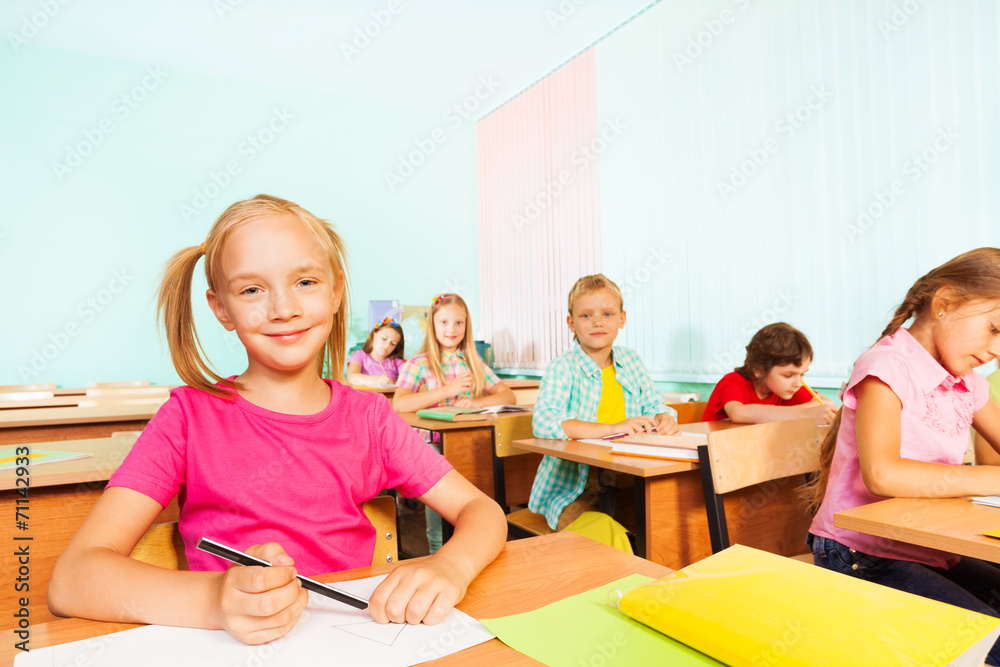 Children write in exercise books and sit at tables Children write in exercise books and sit at tables
