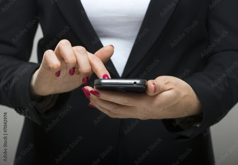 Businesswoman touching smartphone in her hands Businesswoman touching smartphone in her hands
