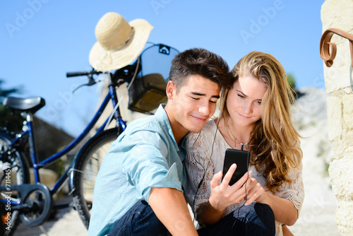 happy young couple teenager sightseeing together summer bicycle