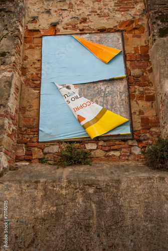 Vecchi poster pubblicitari strappati affissi su muro photo