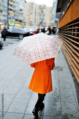 Colorful kid girl with umbrella on city street