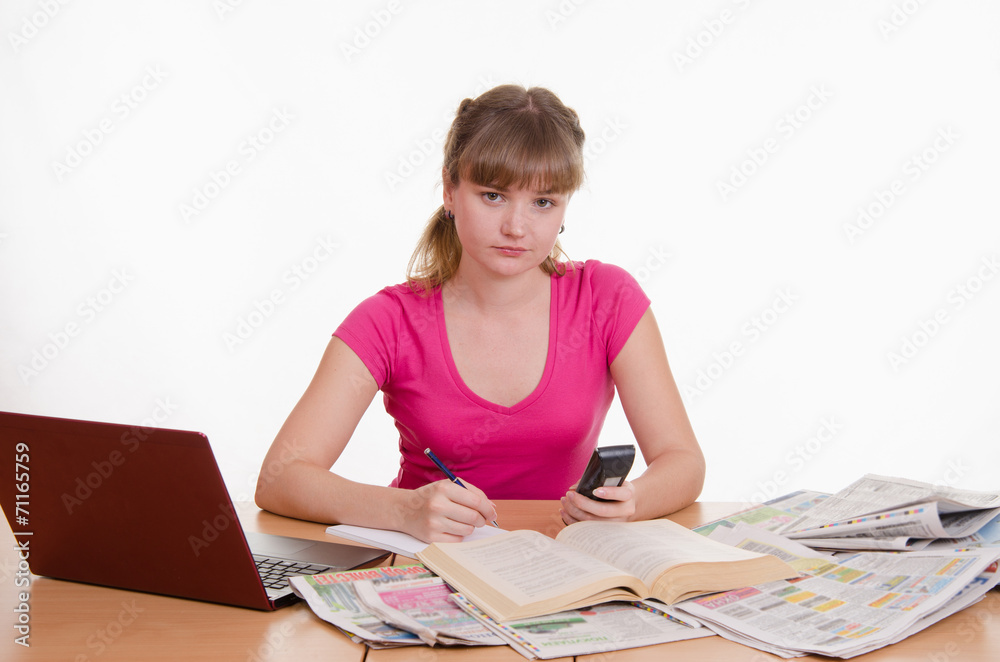 The girl writes a phone number from directory to notebook The girl writes a phone number from directory to notebook