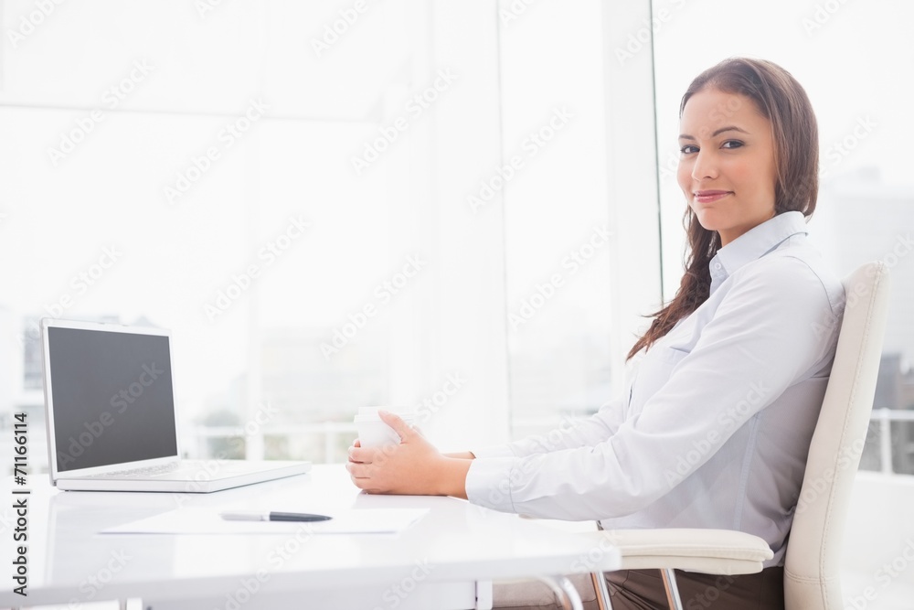 Happy businesswoman having coffee at her desk Happy businesswoman having coffee at her desk