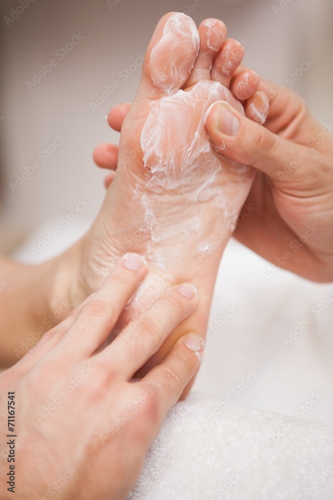 Fototapeta premium Pedicurist covering customers foot in soap