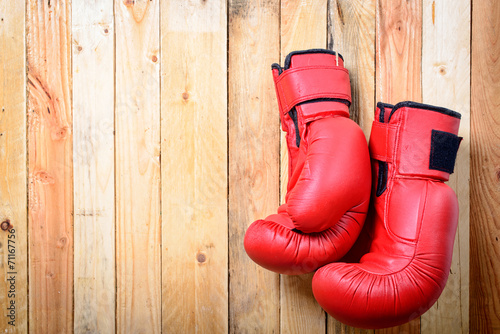 pair of red boxing gloves hanging on the wall © Philipimage