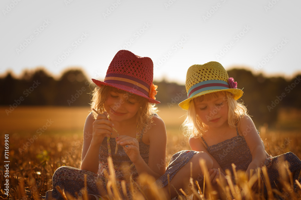 Two girls sitting in a cornfield