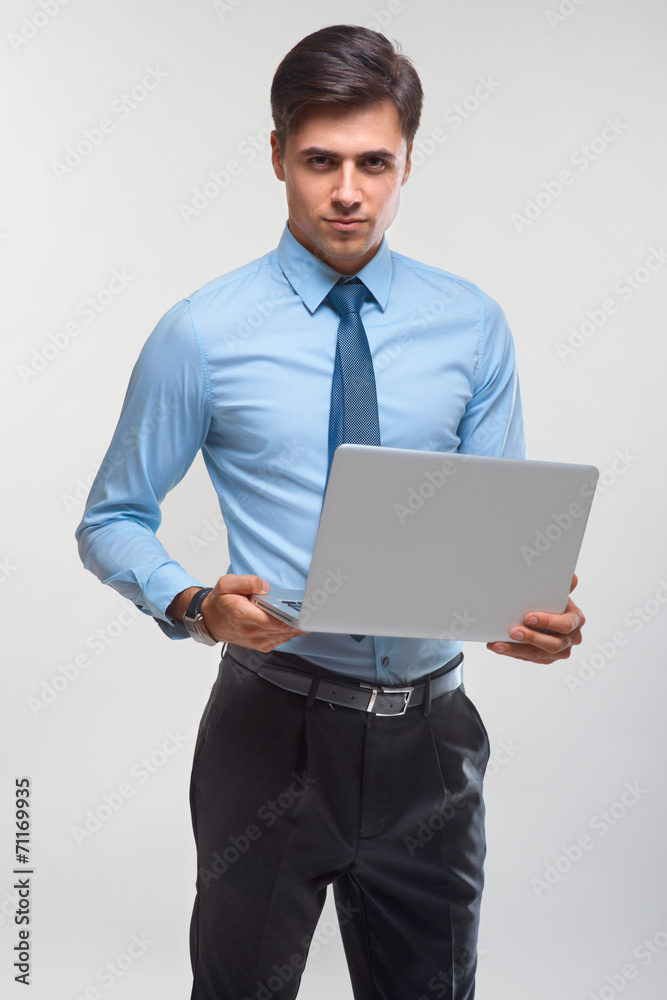 Business man holding a laptop against a white background Business man holding a laptop against a white background