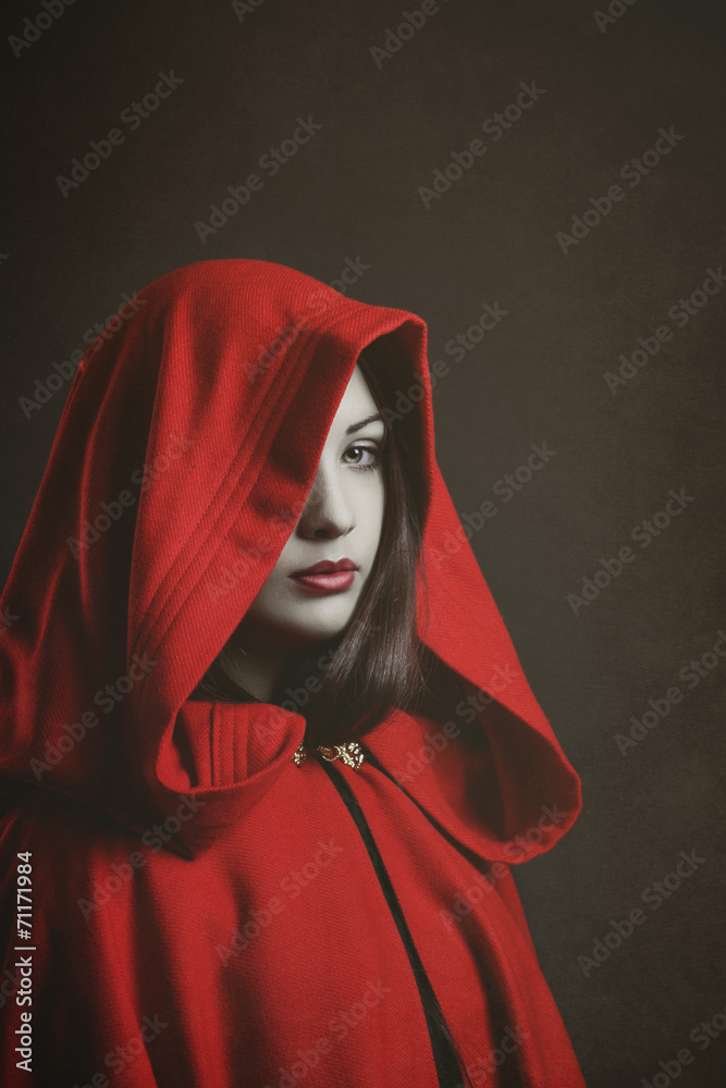Fototapeta premium Studio portrait of mysterious woman hooded in red