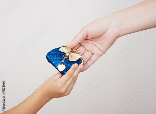 hands of mother gives the purse to her little daughter
