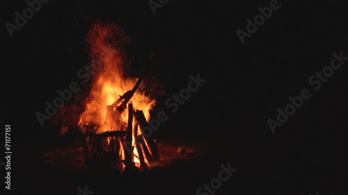 Slow motion demolishing campfire in the middle of the night.