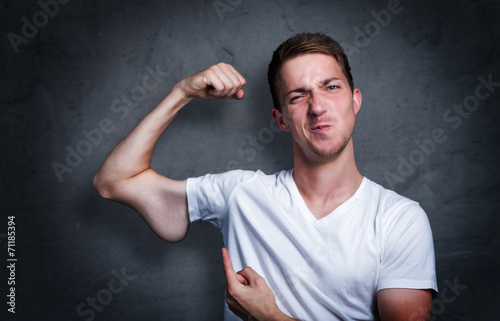 Junger mann zeigt auf seinen verkümmerten Arm