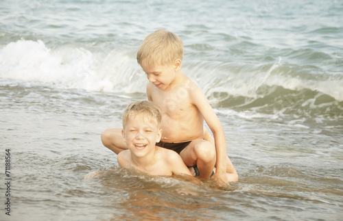Happy twin children enjoying summer day on a beach