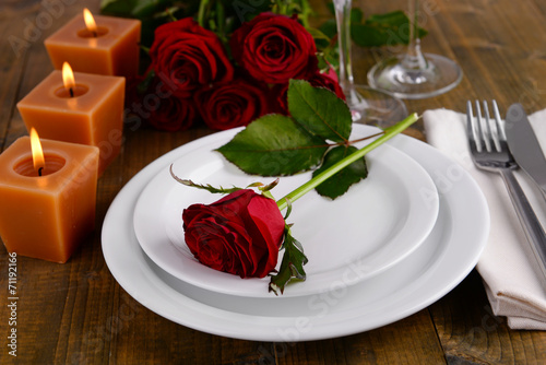 Table setting with red rose on plate