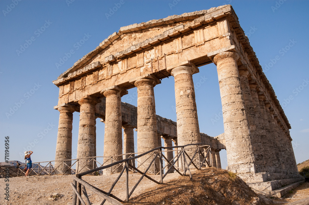 Fototapeta premium Ancient Greek temple with a tourist taking a picture