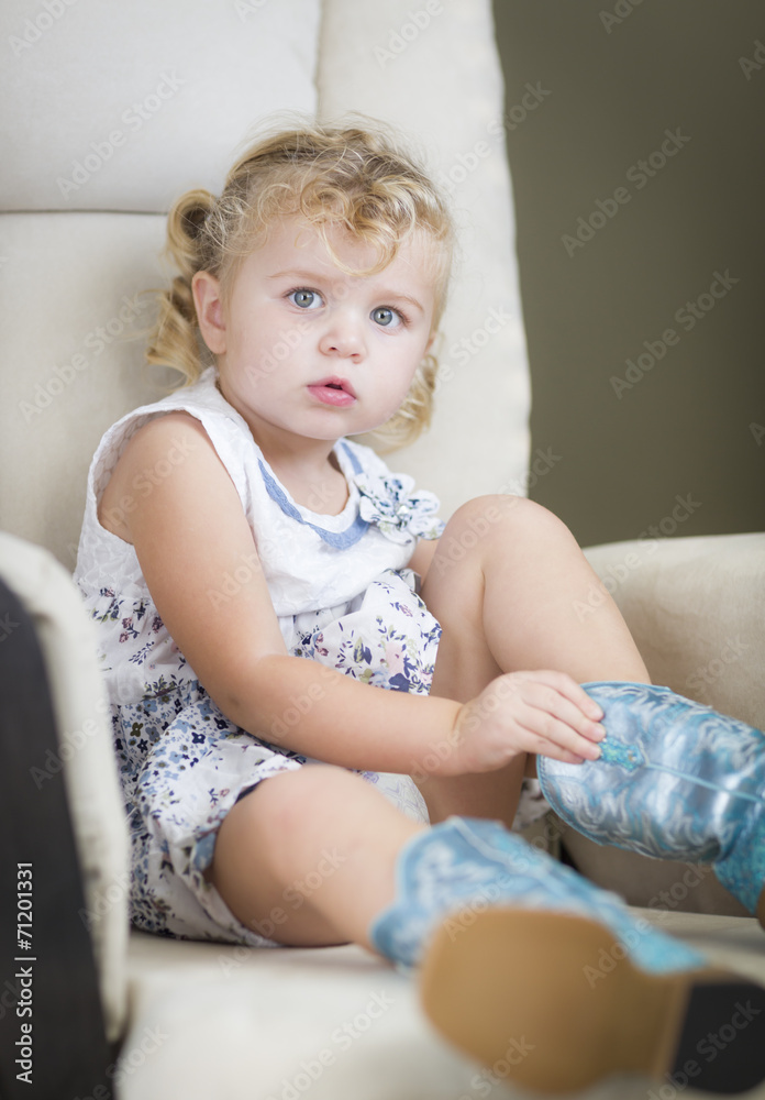 Blonde Haired Blue Eyed Little Girl Putting on Cowboy Boots Blonde Haired Blue Eyed Little Girl Putting on Cowboy Boots