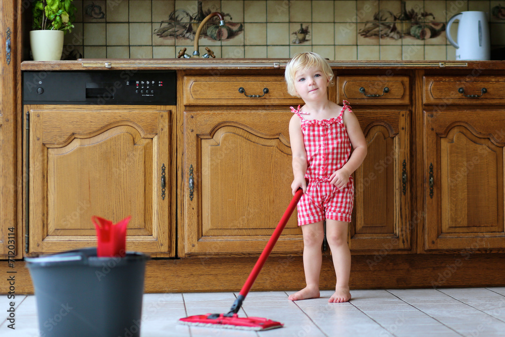 Little girl helping with housekeeping mopping the floor Little girl helping with housekeeping mopping the floor