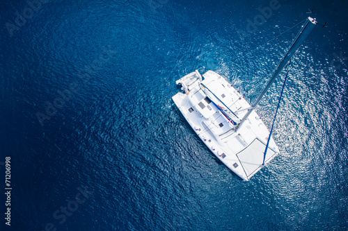 View to catamaran sailing in open sea at windy day. Drone view photo