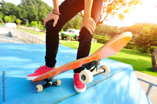  woman legs skateboarding at skatepark 