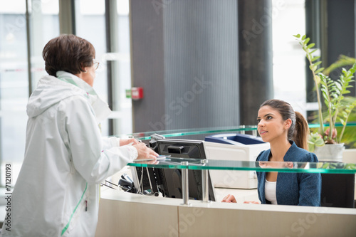 Woman discussing at reception desk