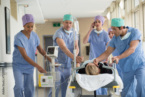 Medical professionals pushing patient on gurney in a hospital photo