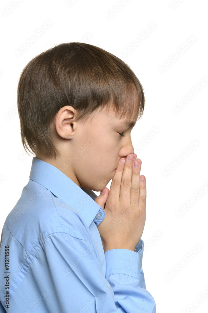 Young sad praying boy standing isolated Young sad praying boy standing isolated