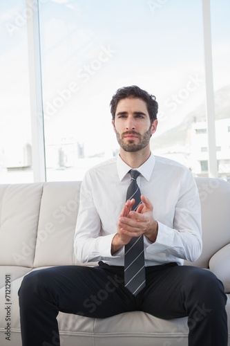 Businessman clapping while sitting down