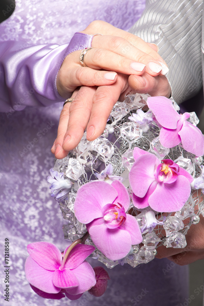 Fototapeta premium Hands with wedding rings and fower bouquet