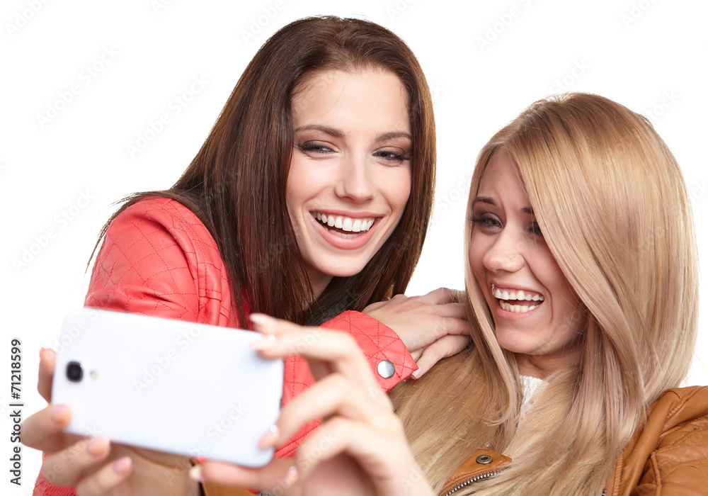 portrait of two beautiful girls making selfies at studio portrait of two beautiful girls making selfies at studio