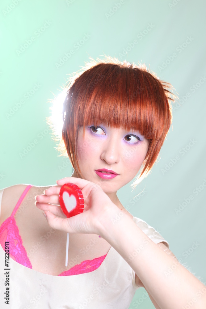 Girl with red hair with a lollipop in a white dress Girl with red hair with a lollipop in a white dress