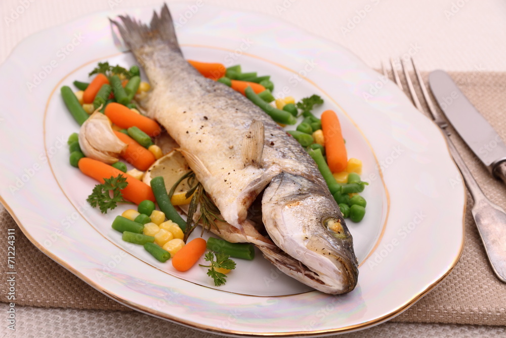 Grilled whole sea bass with vegetables and lemon