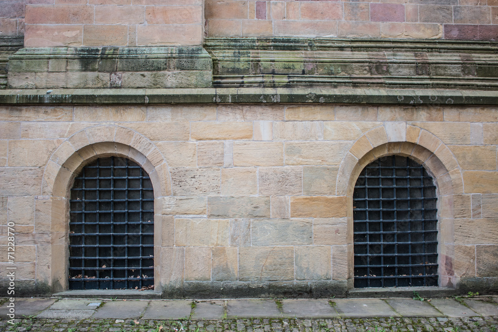 Hintergrund gelbe Sandsteinmauern mit vergitterten Fenstern Stock