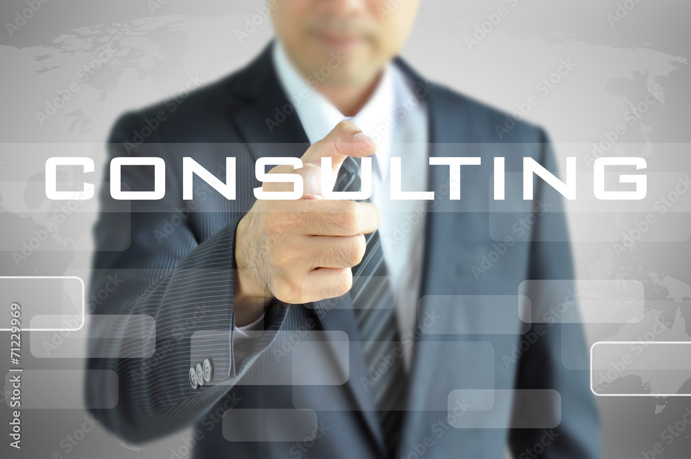 Businessman hand pointing on CONSULTING word on virtual screen Businessman hand pointing on CONSULTING word on virtual screen