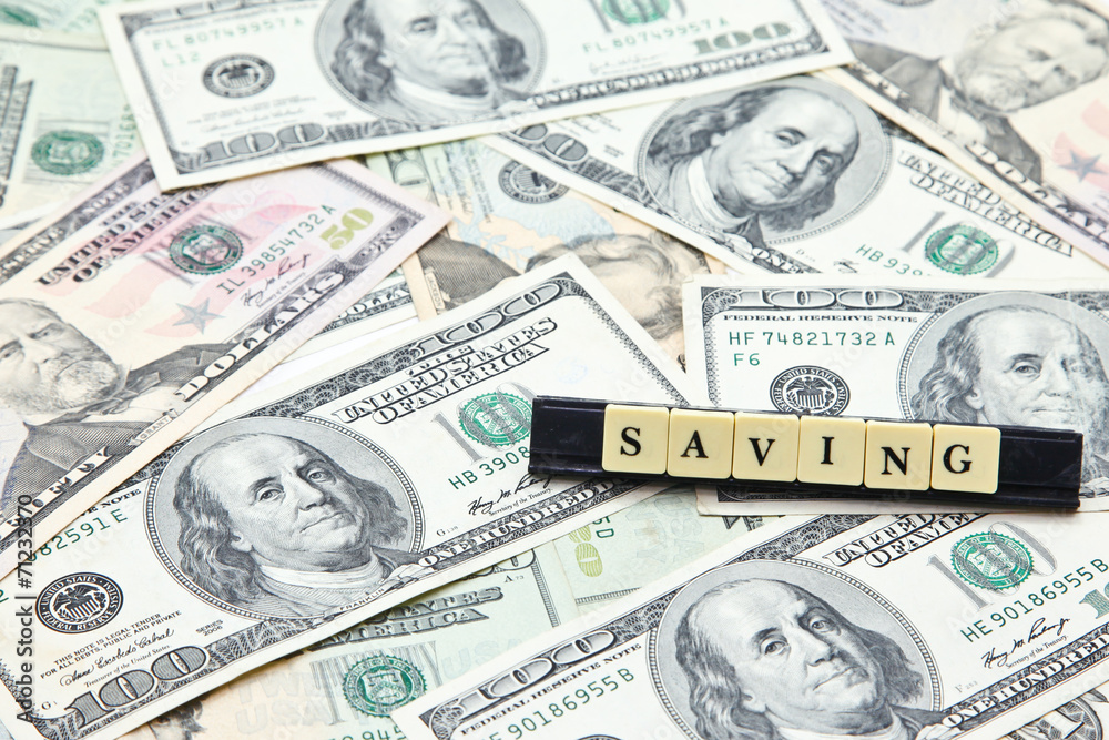 Word saving on pile of US dollar banknotes Word saving on pile of US dollar banknotes