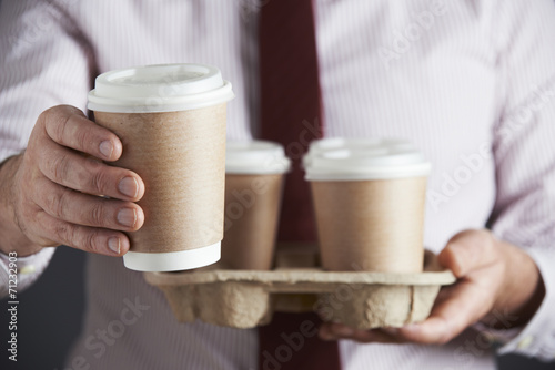 Businessman Holding Tray Of Takeaway Coffee