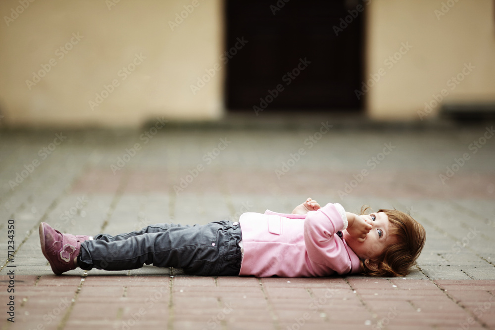 little girl lying on asphalt portrait